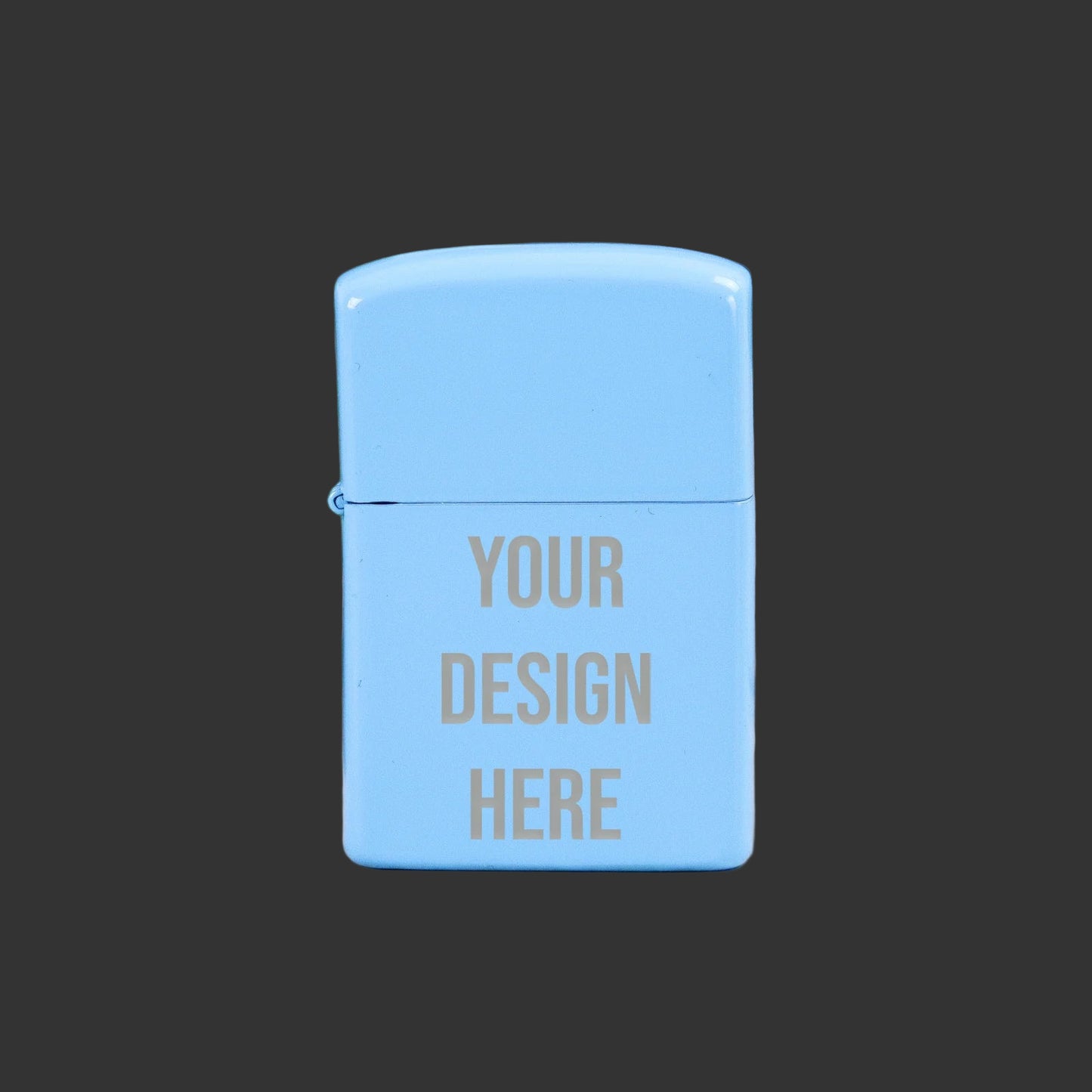 Light blue Zippo-style lighter with 'Your Design Here' text on a wooden surface with green leaves in the background