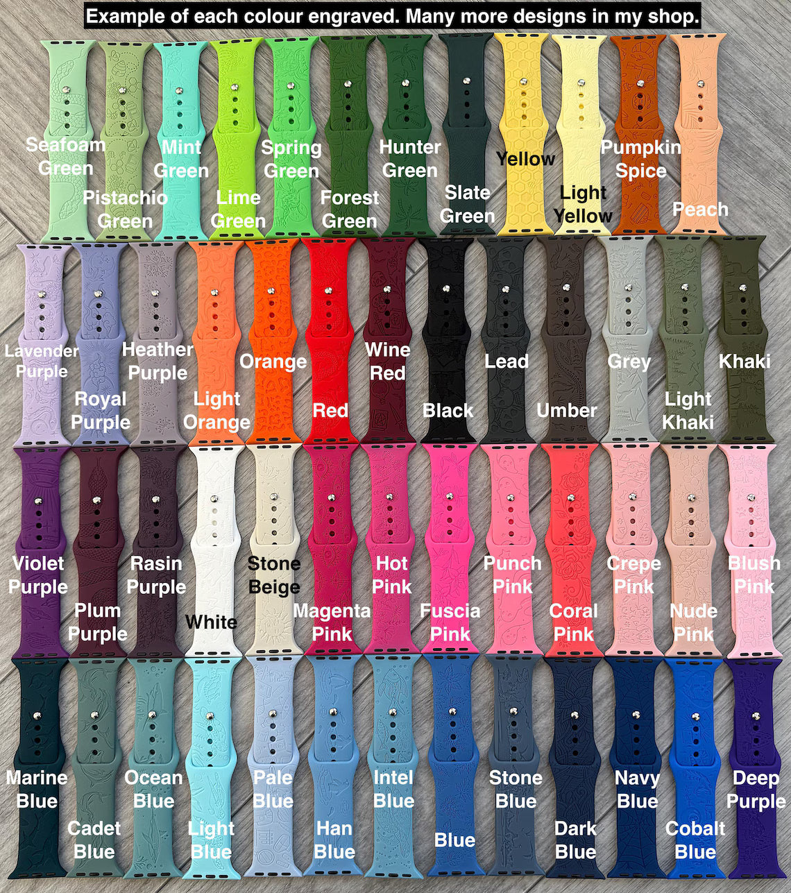 Assorted engraved Apple Watch straps in 42 colors arranged on a wood surface, each labeled.