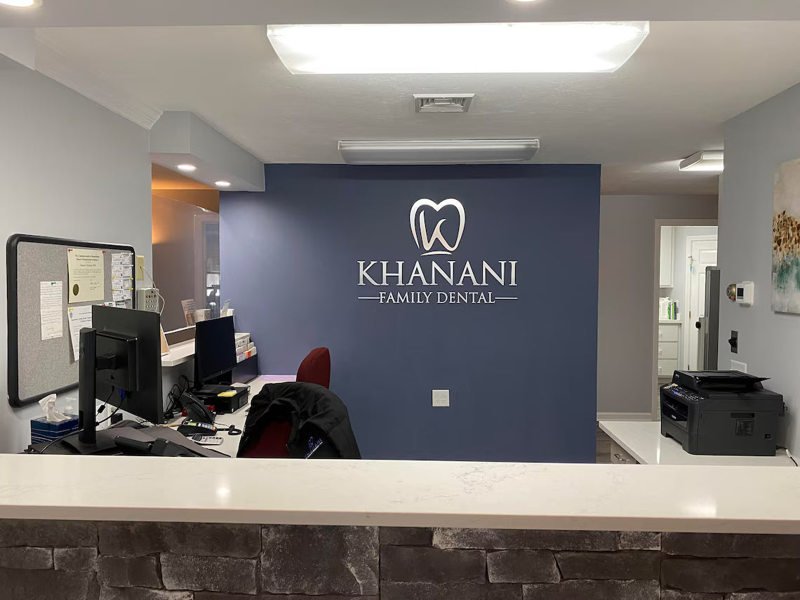 Dental office reception area with 'Khanani Family Dental' logo on a blue wall.