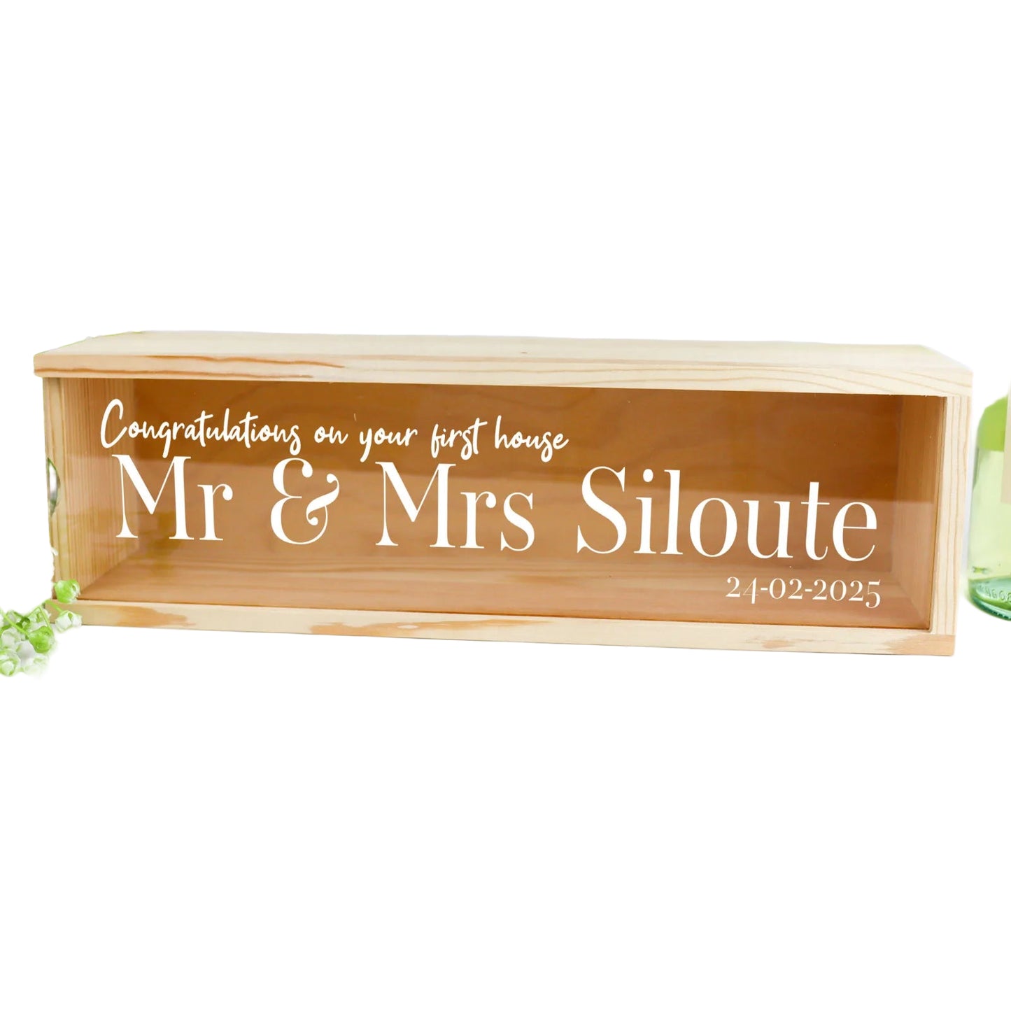 Wooden box with engraved text 'Congratulations on your first house Mr & Mrs Siloute' on a white background.