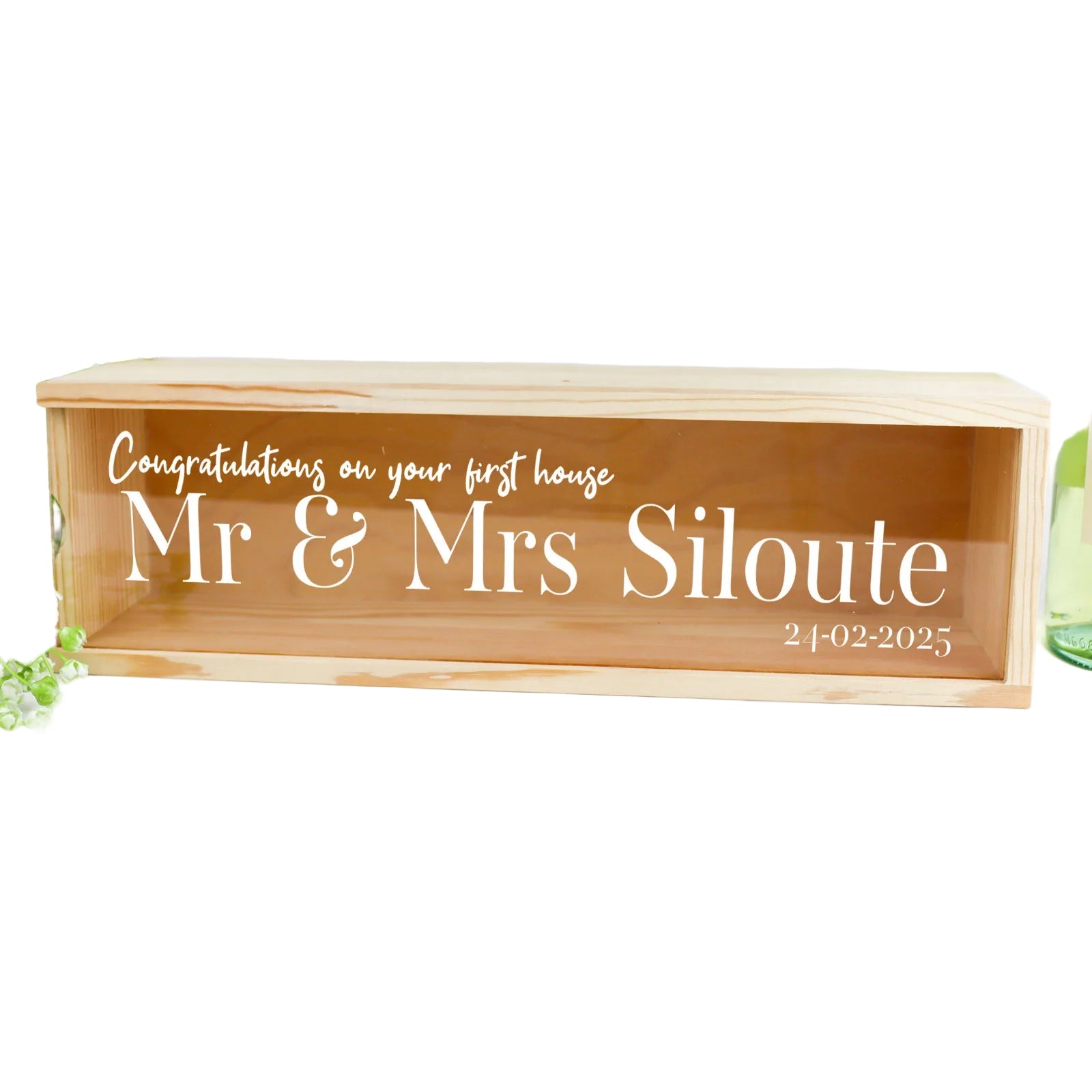 Wooden box with engraved text 'Congratulations on your first house Mr & Mrs Siloute' on a white background.