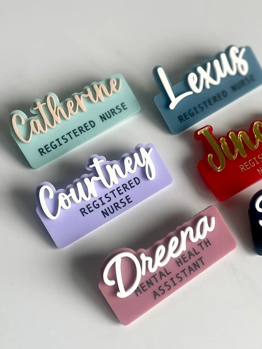 Colorful custom nurse and mental health assistant name badges with engraved titles on a white background